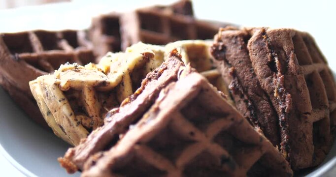 Close up of assorted sweet waffles stacked on a plate