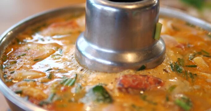 Close up of Tom Yum Goong hot and sour soup boiling in Thai hot pot