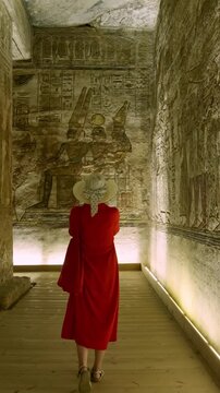 Woman in a red dress exploring the temple in Abu Simbel, Egypt.