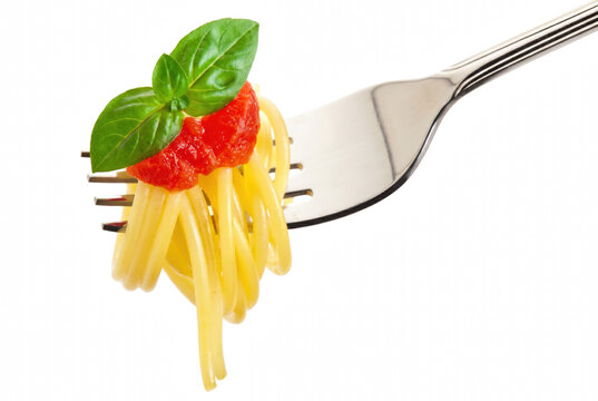 Spaghetti pasta with tomato sauce and fresh basil leaves on a fork