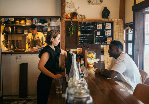Woman serving a customer at a bar in Japan