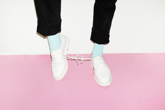 Conceptual image of person wearing shoes and having a knot in the lace