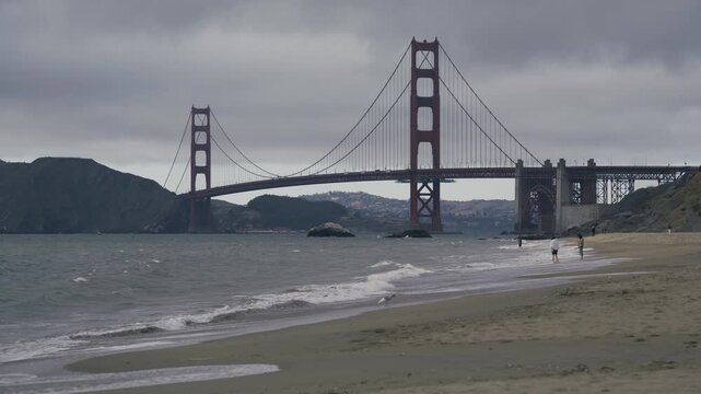 Seagulls And People On Beach Near Golden Gate Bridge In San Francisco On Overcast Day - Wide Shot