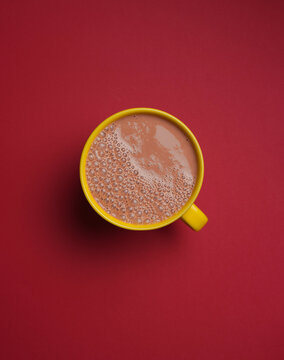 A cup of hot chocolate from above against red