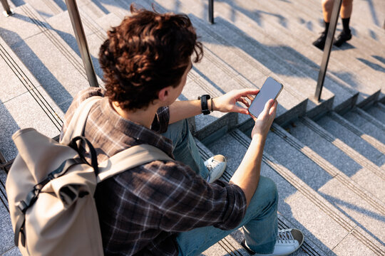 Young man on steps using phone