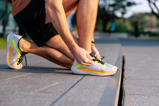 Runner tying shoelaces before a run in the park.