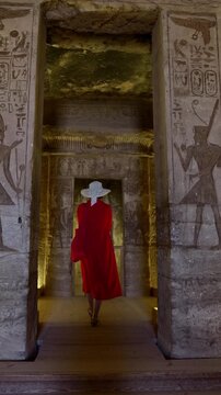 Woman in a red dress exploring the temple in Abu Simbel, Egypt.