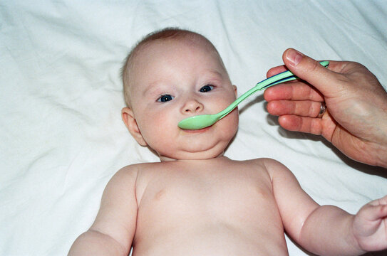 Baby learns to eat with a spoon for the first time