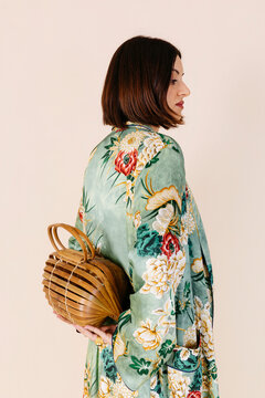 Woman wearing floral kimono holding bamboo bag