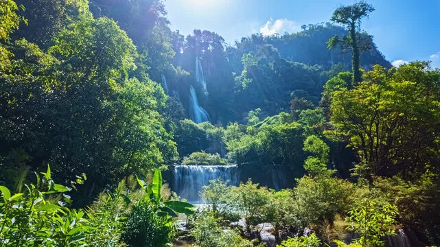 Golden sunlight shines above Thi Lor Su Waterfall while fresh mist rises from the powerful stream, creating one of the most breathtaking natural scenes in Tak Province, Thailand.