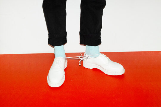 Conceptual image of person wearing shoes and having a knot in the lace