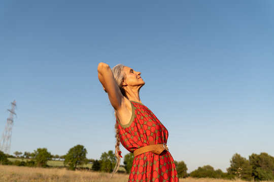 cAREFREE SENIOR WOMAN Enjoying the Outdoors Under a Clear Blue Sky