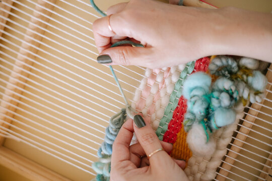 Hands making weaving thread