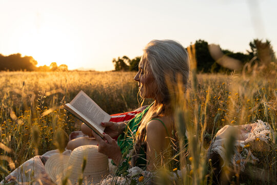 Senior Woman Reading At Sunset

