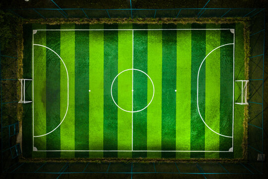 empty football pitch with striped green turf