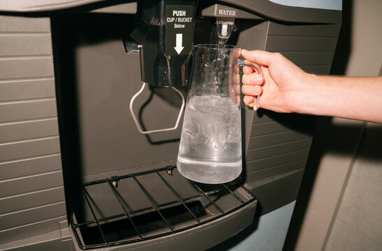 Hand Filling Pitcher at Water Dispenser