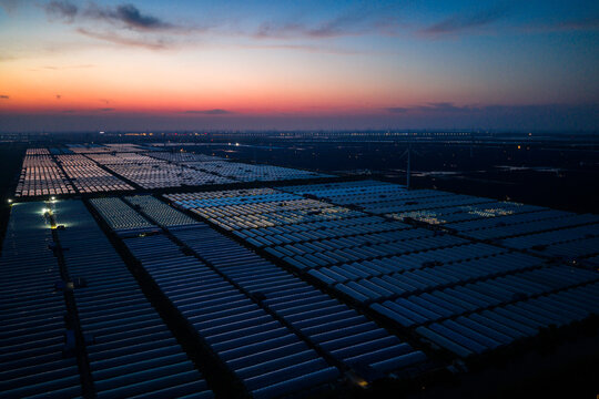 vast greenhouse complex at sunset with colorful sky