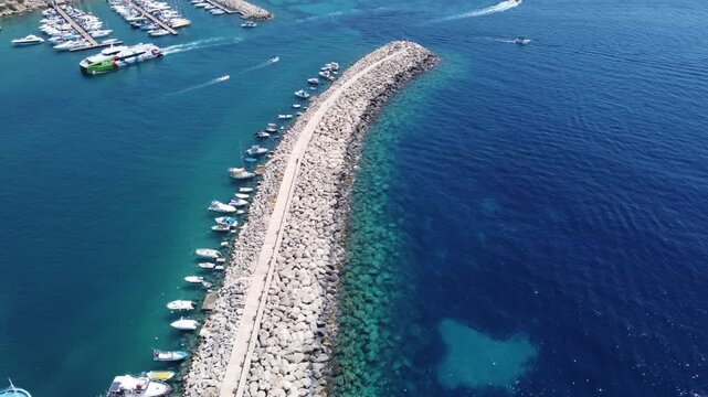Mgarr, Gozo, Malta 29.06.2026 - Aerial view of waterbreak in Mgar Gozo Harboar with boats leaving and entering the port. High quality 4k footage