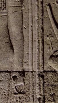 Detailed reliefs of ancient Egyptian deities and hieroglyphs carved on the walls of the Philae Temple. Egypt.