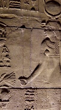 Detailed reliefs of ancient Egyptian deities and hieroglyphs carved on the walls of the Philae Temple. Egypt.