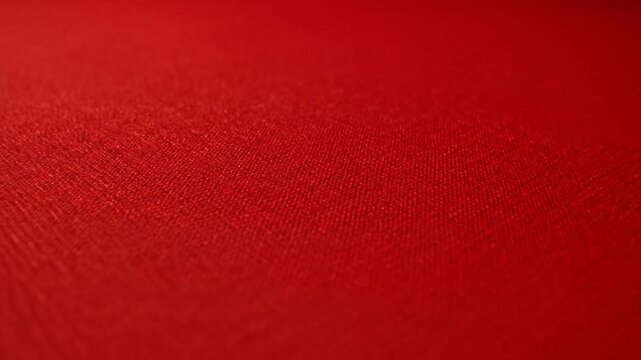 A close up view of a vibrant red fabric texture surface