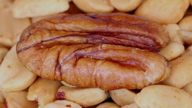 a bowl of peanuts with a walnut on top