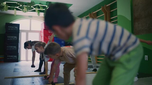 Young children engage in fitness exercises, lifting light dumbbells during a group workout session. Kids are actively exercising, promoting a healthy lifestyle and physical development.