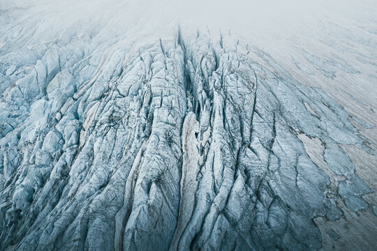 Aerial view of the deep crevasses and icy textures of the Ghiacciaio di Fellaria Est in the mountains of Lanzada, Lombardy, Italy.