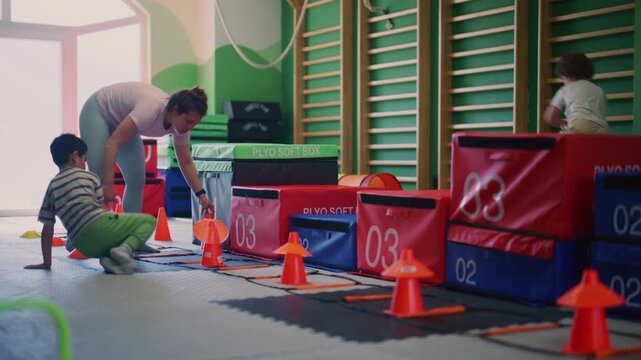 Children actively participate in a fun and engaging fitness session at the gym. Youngsters enjoy physical activity and skill development during their training.
