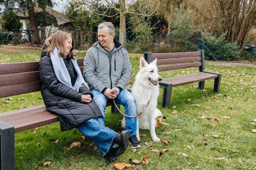 Fototapeta premium Father and daughter enjoying time with white shepherd dog