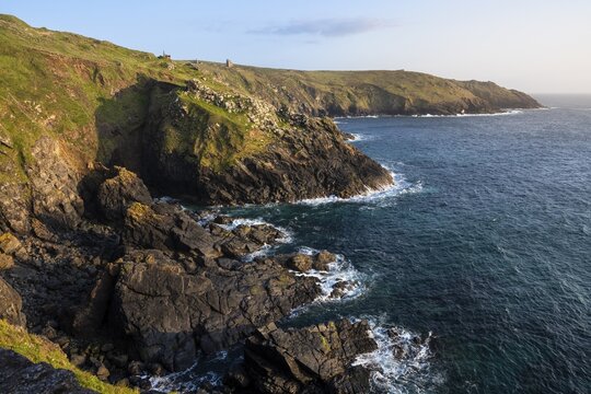 Coastal landscape at Botallack Mine, also known as Crown Mine. The ruins of Wheel Edward in the background. Sea and rocks. Evening, golden hour. Good weather, blue sky. Botallack, Penzance, Cornwall, England, Great Britain
