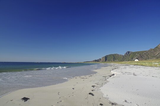 Beautiful beach with clear blue sky, gentle waves and mountains in the background, Bleik, Vesteralen, Langoya, Nordland, Norway