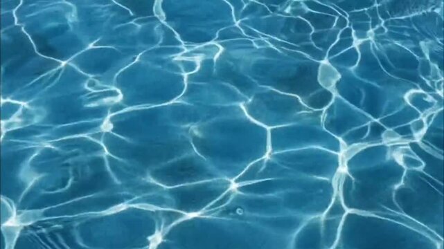 Sunlight on Water Surface: Mesmerizing patterns of light and shadow dance across a tranquil blue water surface, creating an abstract and soothing visual.