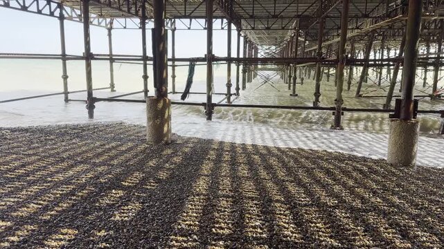 Shadows cast under seaside structural pier 4K