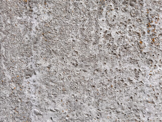 Obraz premium Rough gray concrete surface texture with porous holes and weathered patterns background