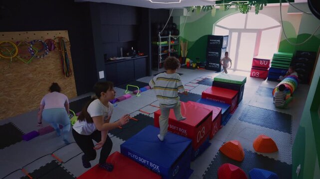 Children engage in a variety of dynamic fitness activities and play within a vibrant indoor gym setting. They are actively developing their motor skills and enjoying a fun, stimulating environment.