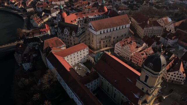 Cinematic drone shot of Karlsplatz and Hofkirche church tower in Neuburg an der Donau showcasing a majestic aerial view of the historic landmark square under a clear horizon line