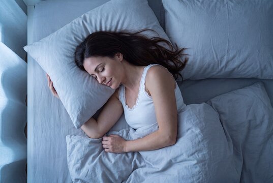 Young woman sleeping peacefully in bed at night