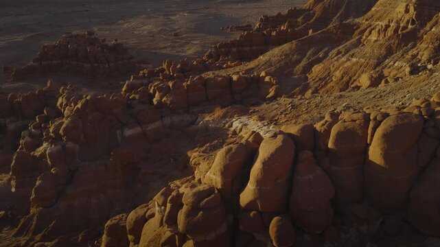 An aerial flyover sandstone rock formation and hoodoos at sunrise, Little Egypt, Utah