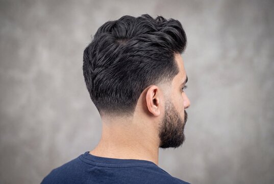 Back view of a man with a stylish textured haircut and a clean skin fade
