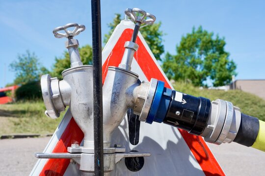 Fire hose connected to standpipe beside warning sign