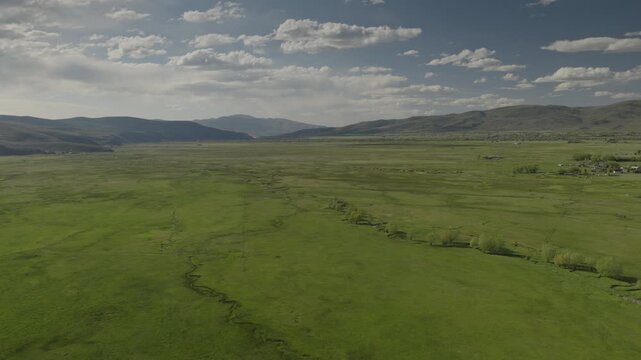 An aerial flyover of marshland and meadows near rural farms, Kamas, Utah