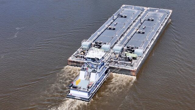 Tug boat pushing a set of liquid cargo barges North up  the Mississippi River