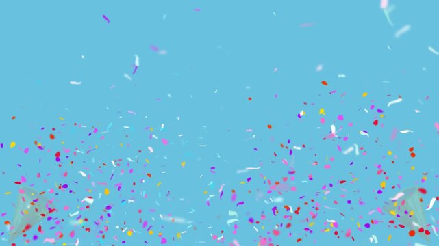 Confetti bursts upward in a vibrant display against a plain blue backdrop for festive occasions.