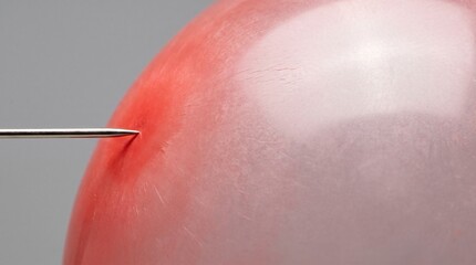 Fototapeta premium Over-Inflated Red Balloon Meeting a Sharp Needle as a Pressure and Risk Metaphor