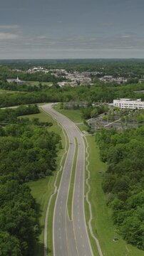 An aerial flyover vertical video of suburban highway and businesses near La Grange, Kentucky
