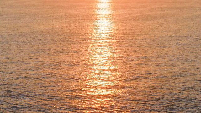 Abstract close up view of calm sea ripples catching bright morning sunlight