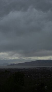 A vertical video timelapse of clouds and an approaching storm moving over Utah Valley and Utah Lake, Cedar Hills, UT