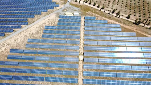 Aerial view flying over solar panel farm producing renewable energy