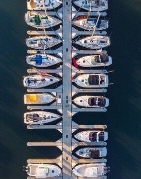 Aerial view of sailboats and motorboats docked in neat rows at a marina in Los Angeles, California, United States.